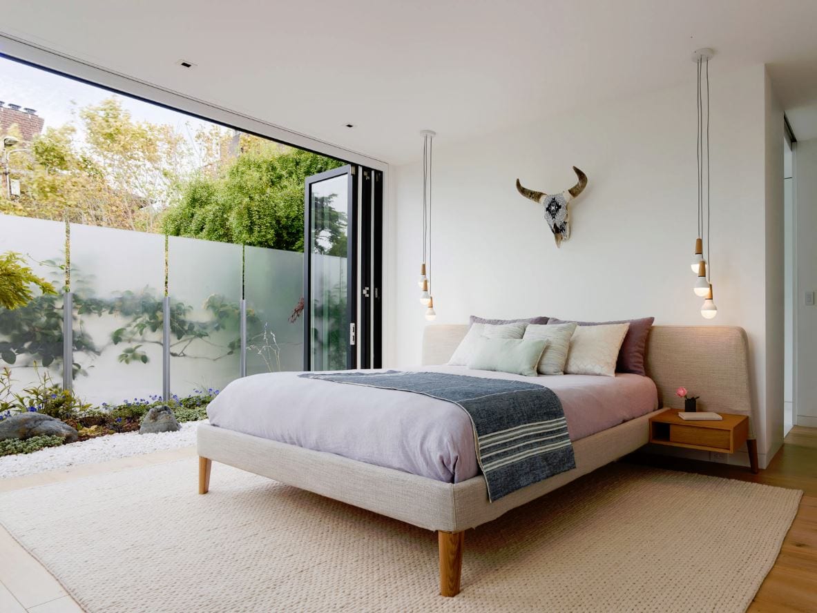 Wood bifold doors open bedroom to outdoors