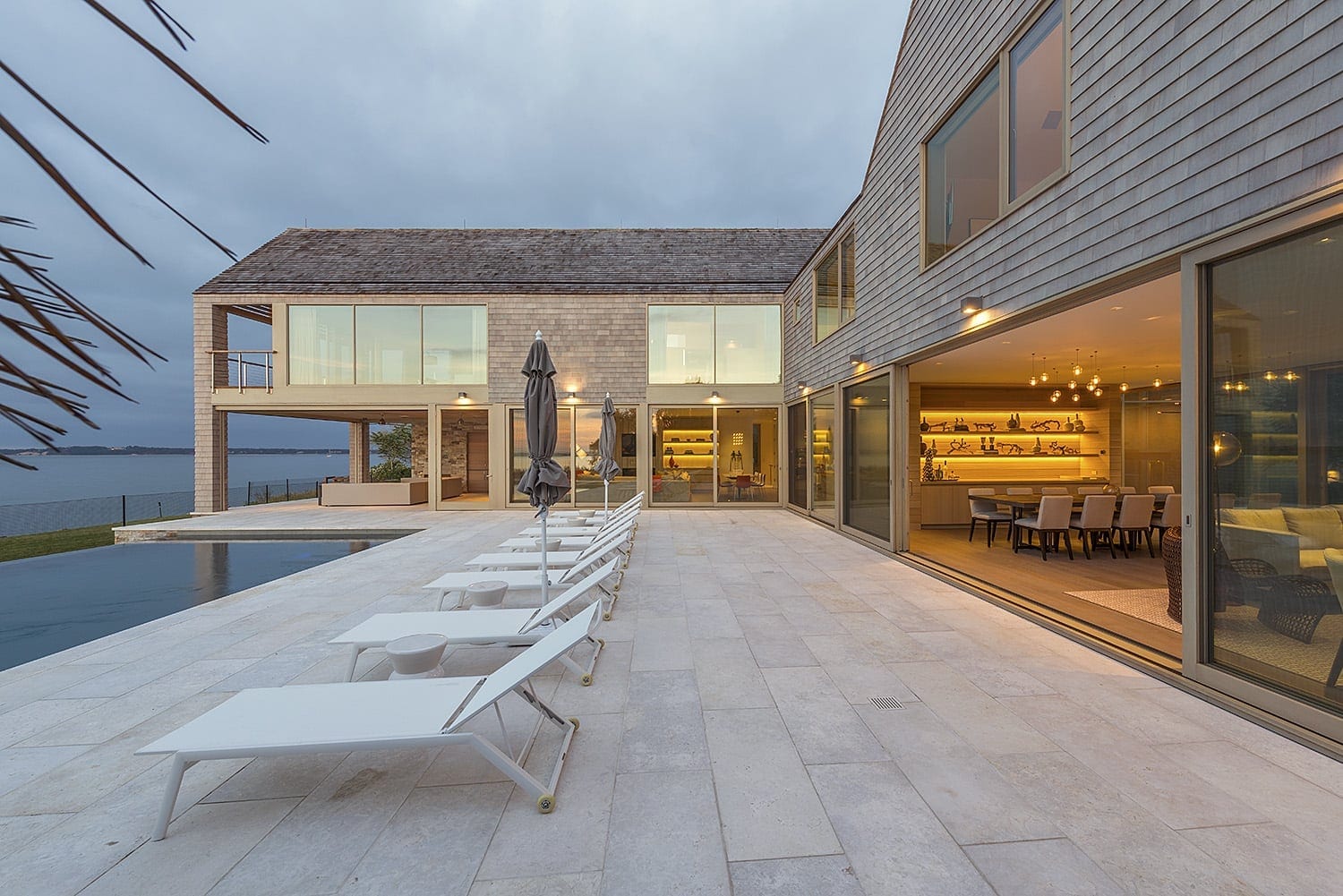 Massive wood lift and slide doors open to patio on the water