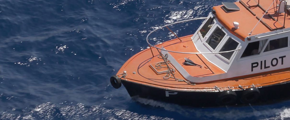 Harbor pilot ship floats in the water waiting to guide a ship into shore